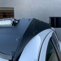 Close up of front right corner of Economy Roof Rack on a white Toyota Tacoma - Cali Raised LED