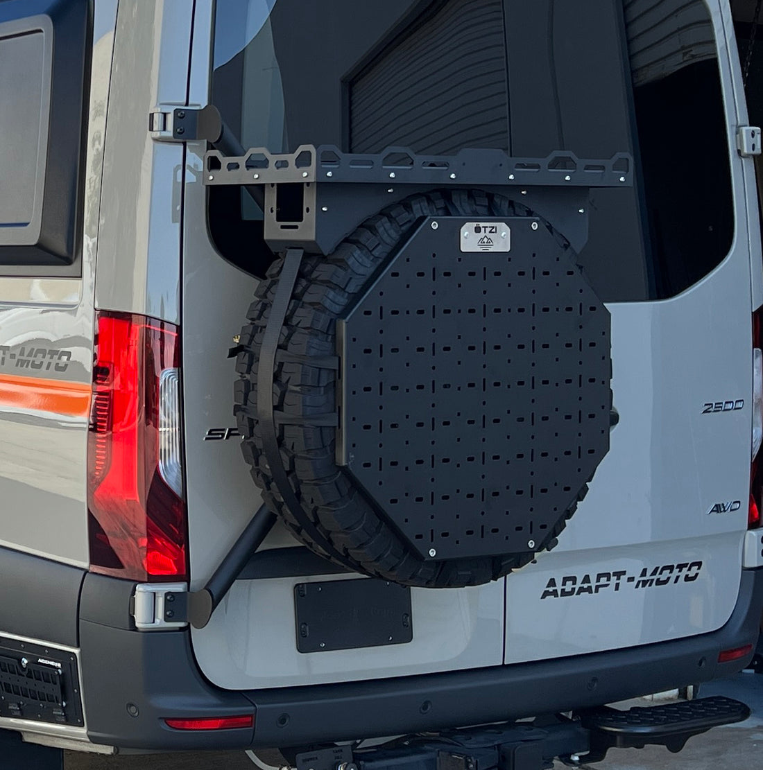 Rear view of a van with a mounted spare tire carrier and utility panel.