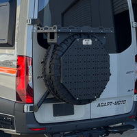 Rear view of a van with a mounted spare tire carrier and utility panel.