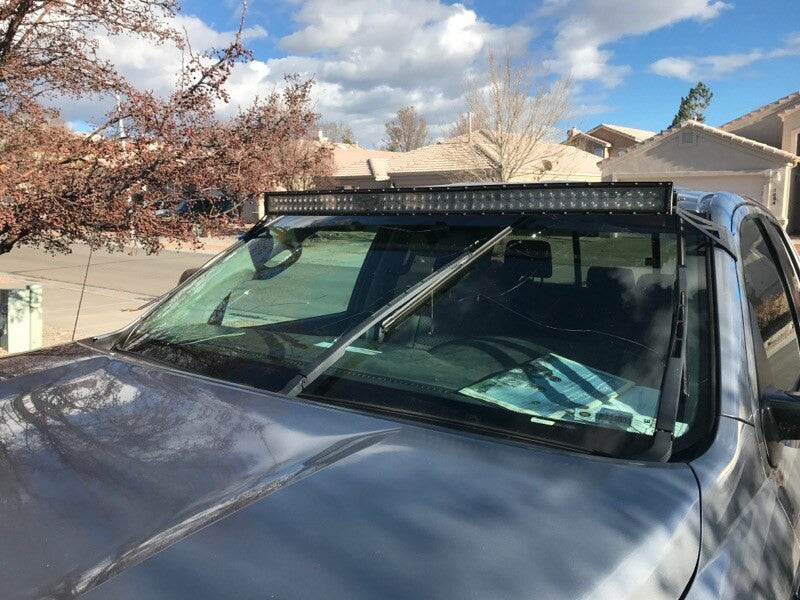 Curved LED light bar and roof mounting brackets on gray Toyota Tundra - Cali Raised LED