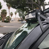 Close-up of curved LED light bar and roof mounting brackets on Toyota 4Runner - Cali Raised LED